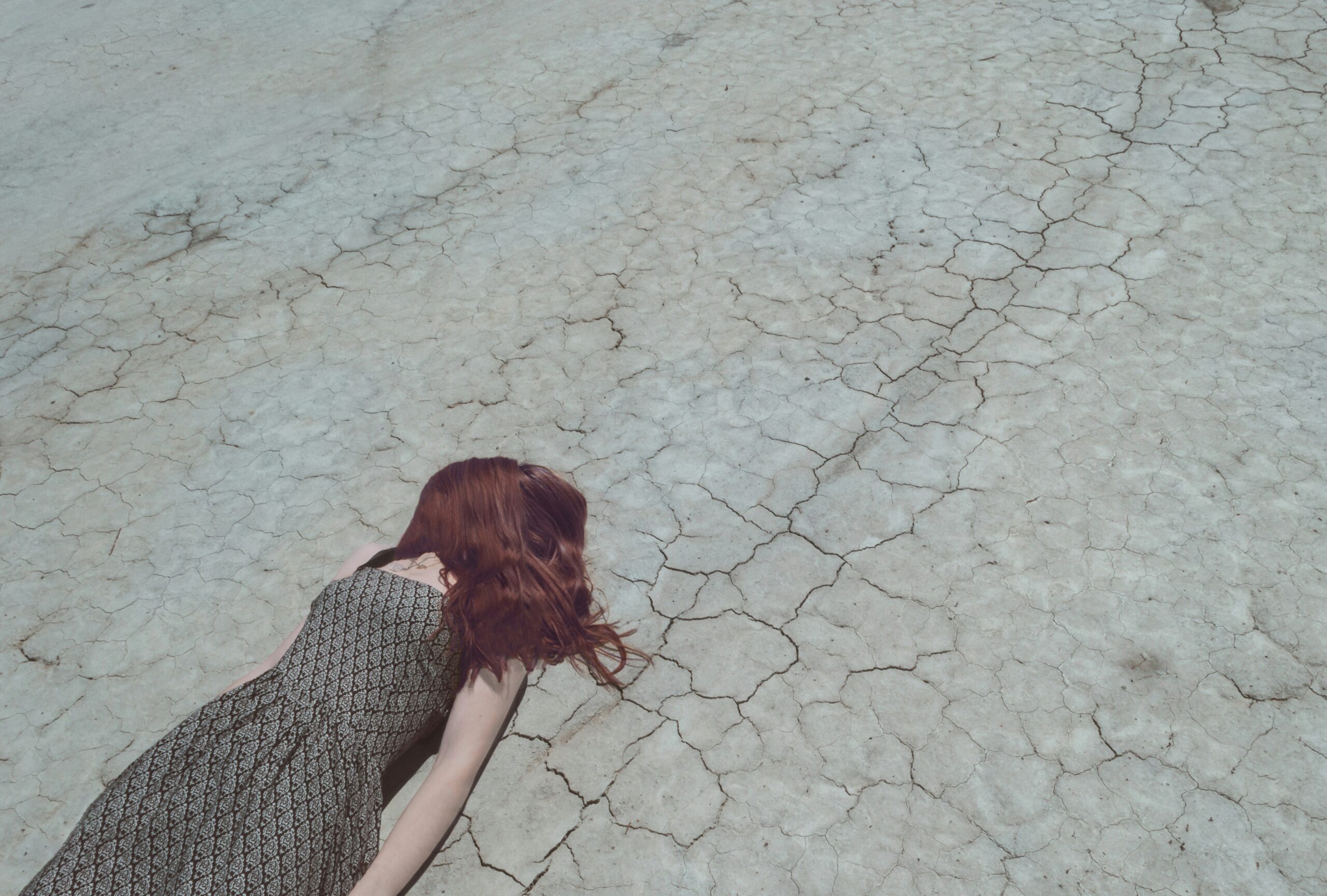 woman lying on dry ground